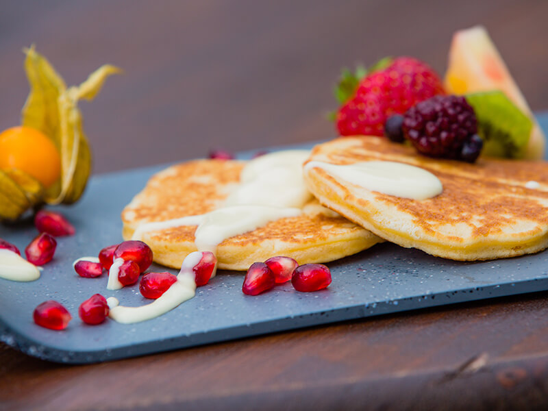 Amerikanische Pancakes mit Vanillesosse mit Früchten dekoriert